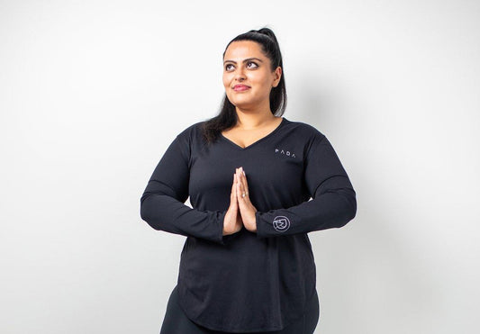 British Indian woman sat down in PADA black gymwear