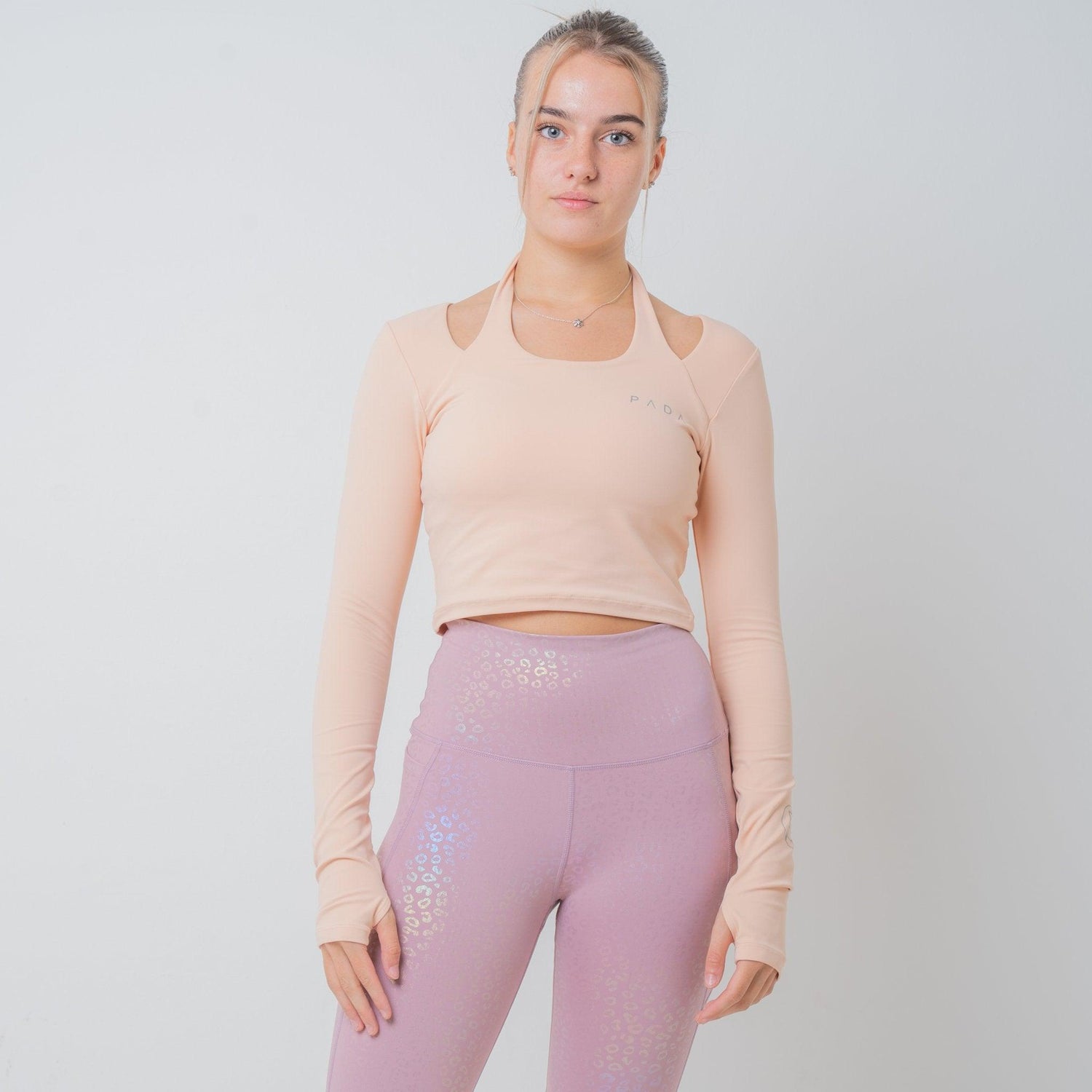 woman wearing nude yoga top cropped and pink iridescent leggings 