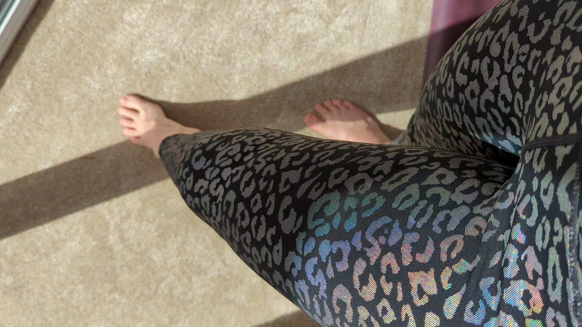 Woman wearing leopard print leggings near a window