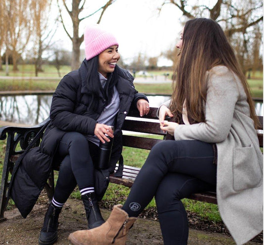 women wearing pada leggings talking on a bench