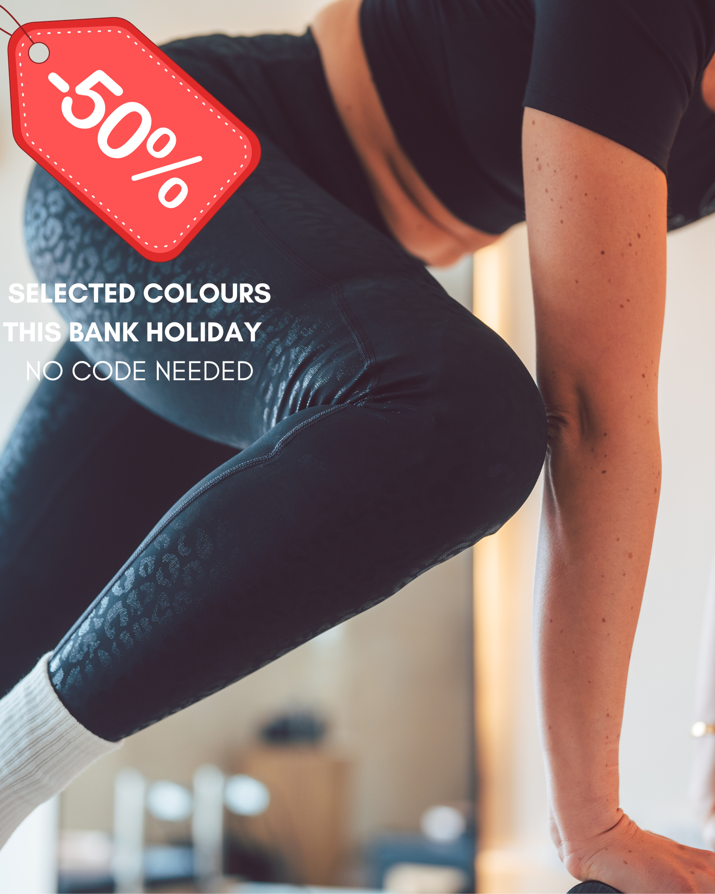 Person wearing black leggings with a promotional tag indicating a 50% discount.